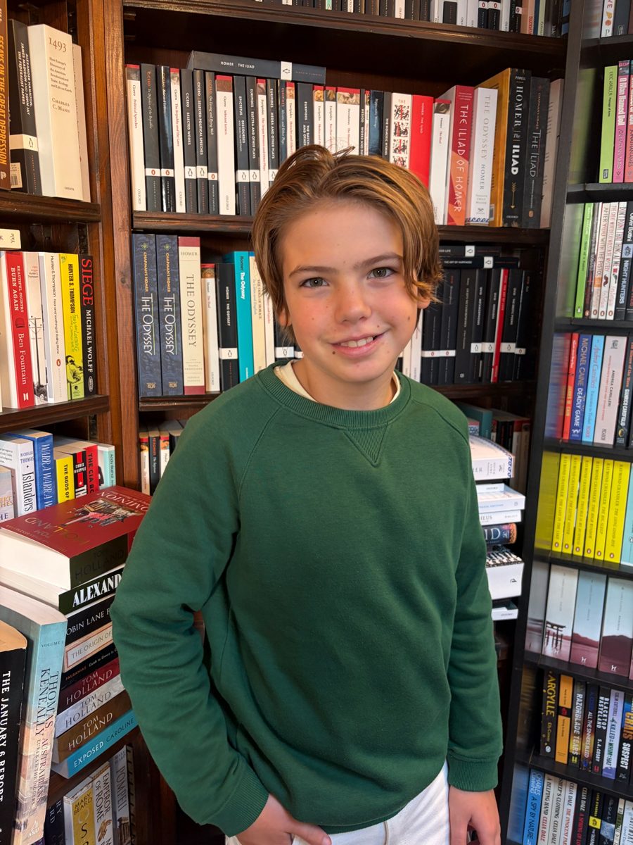 Alex, founder of A Classic Match, standing in front of shelves of classic books